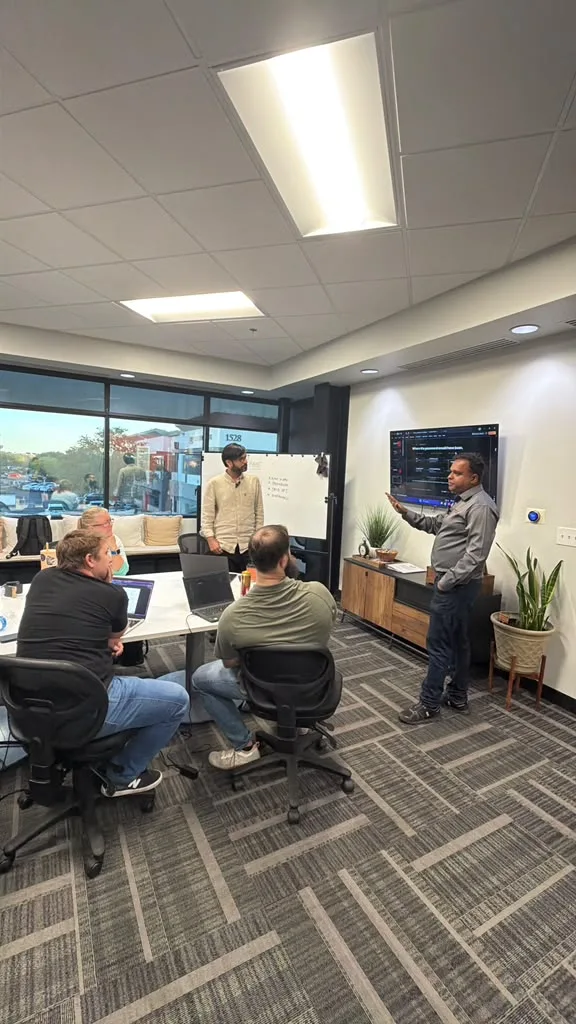 A presenter pointing at a Databricks workspace on the screen while attendees follow on their laptops.